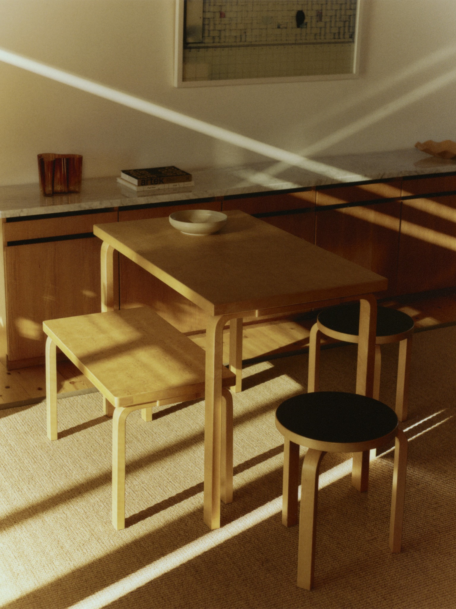 Artek wooden furniture with sunlight and shadows in an interior