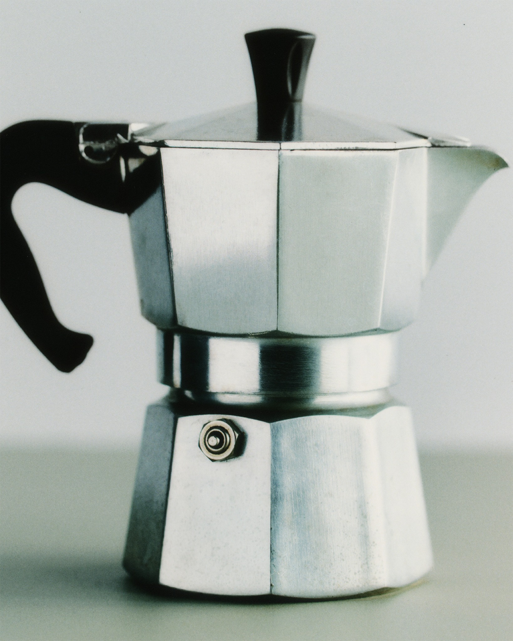 Aluminium moka coffee pot on a pale studio surface