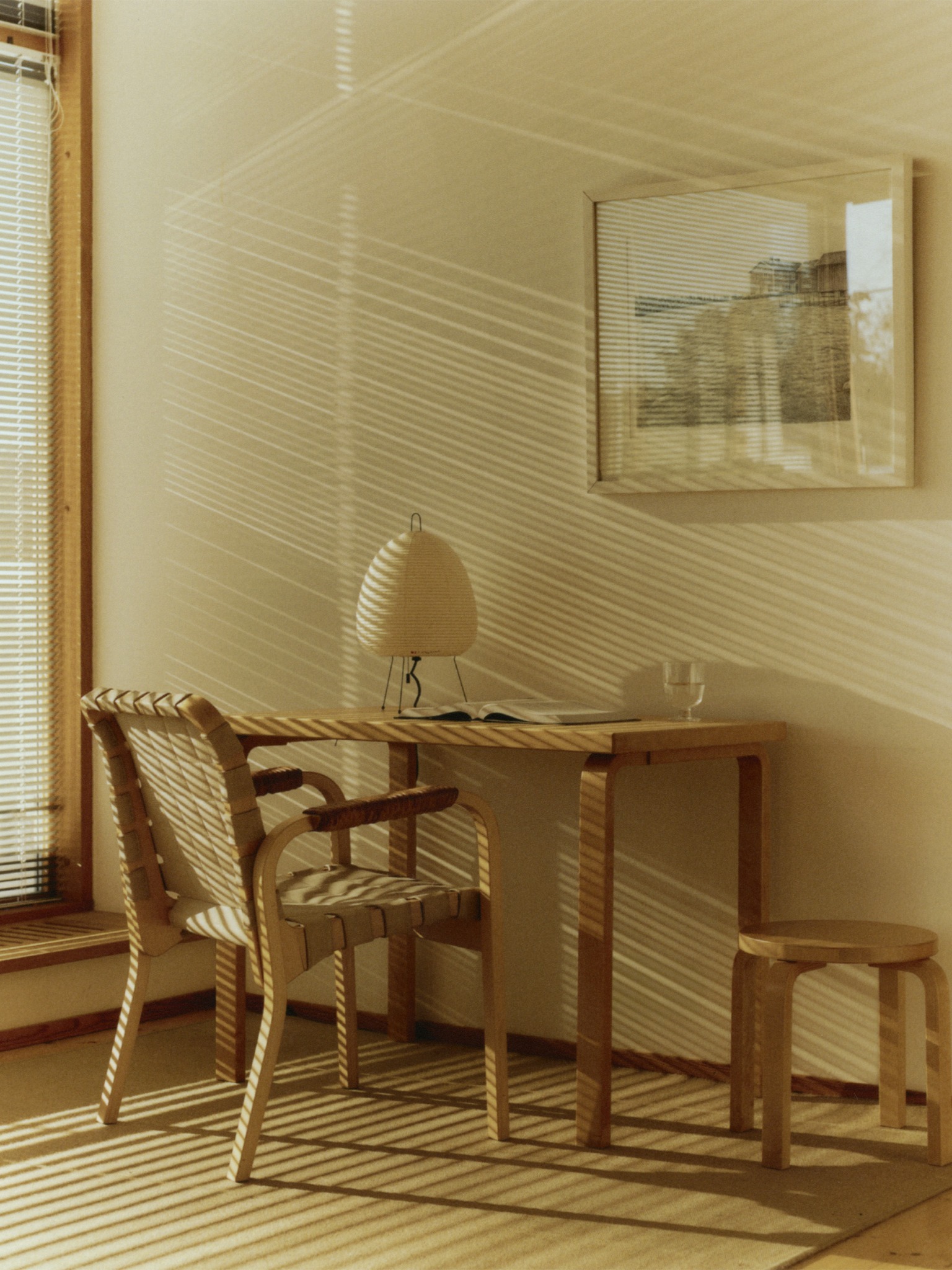 Artek desk, chair and stools in a sunlit interior