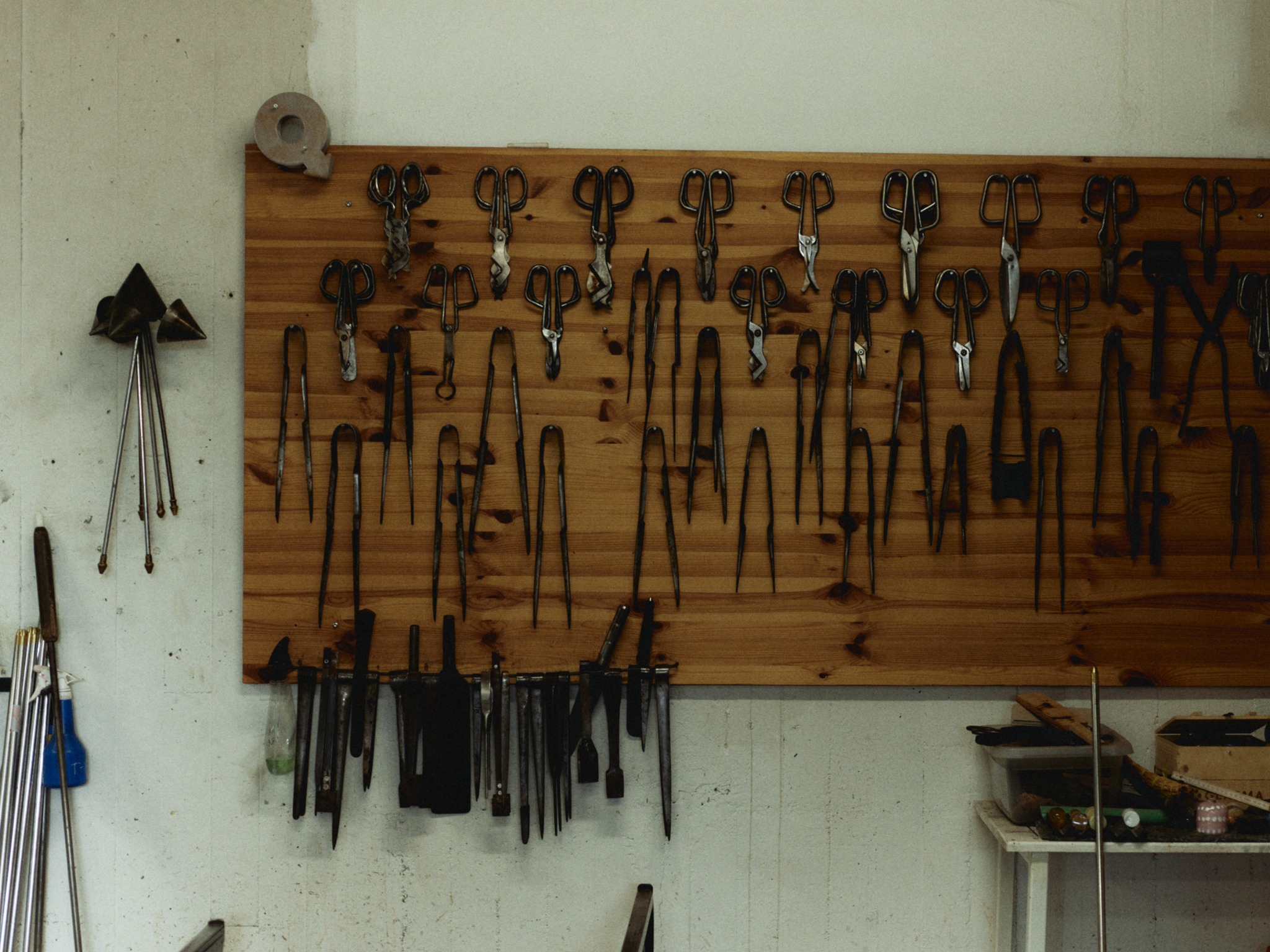 Hand tools hanging on a wooden board inside a workshop