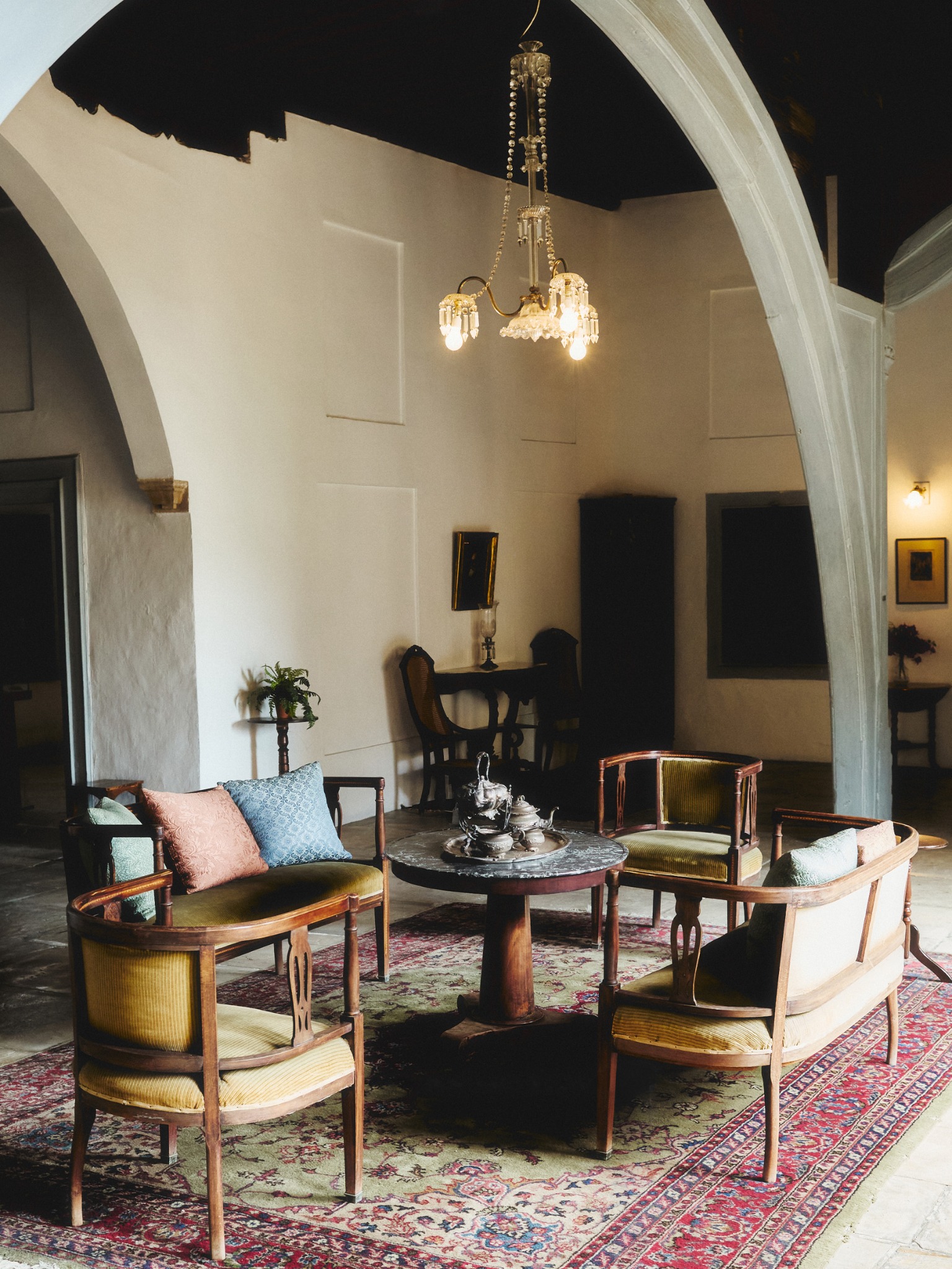 Seating and chandeliers beneath white arches in a Nicosia interior