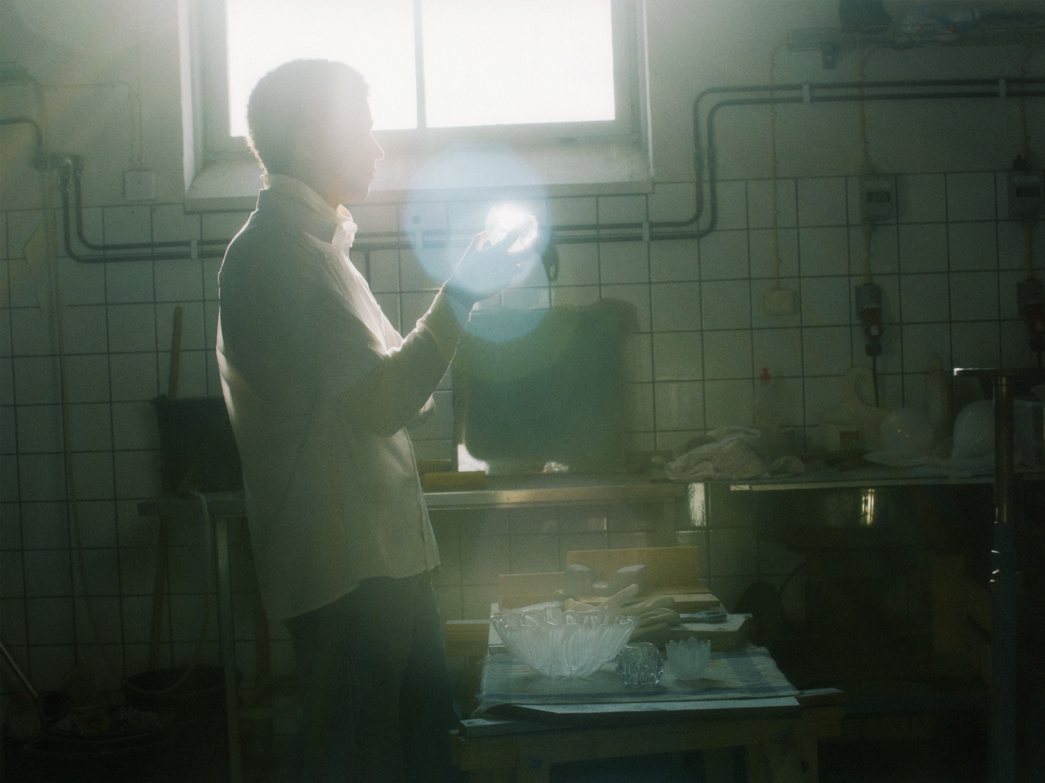 Portrait of Simon Skinner in a sunlit glass workshop
